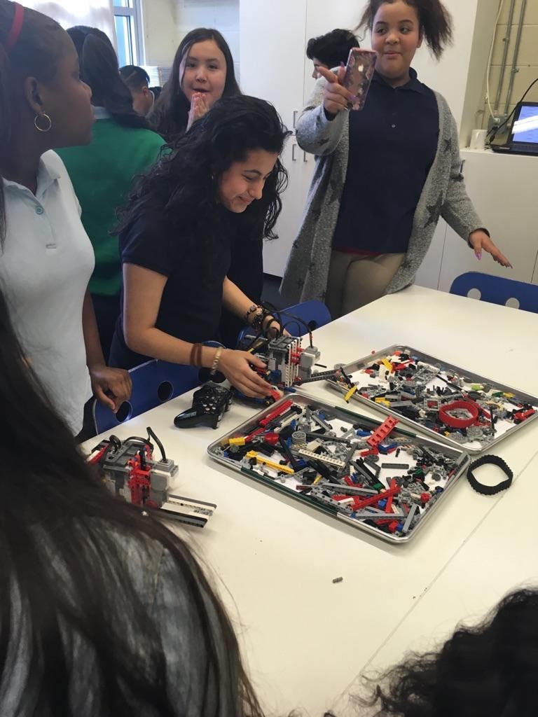  students gathered around a table developing a robot